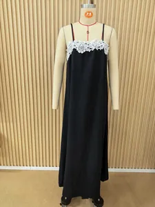 Detailed view of a long black sleeveless dress with white lace trim on neckline.