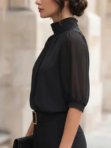 Elegant detail van een zwarte blouse met opstaande kraag en transparante mouwen.