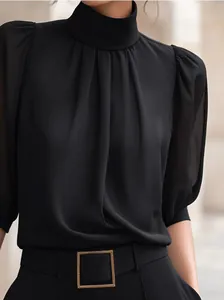 Detail van zwarte chiffon blouse met opstaande kraag en elegante plooien.
