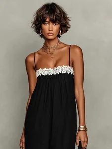Close-up of black summer resort dress with white floral lace trim and thin straps