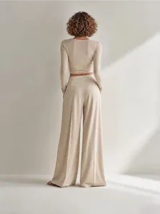 Vista posteriore di un set a due pezzi in maglia beige con top corto e pantaloni larghi