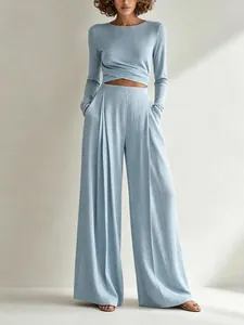Elegante set due pezzi azzurro con top incrociato a maniche lunghe e pantaloni a gamba larga