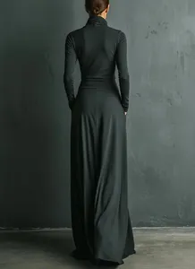 Back view of a charcoal grey long sleeve turtleneck maxi dress with flowing skirt