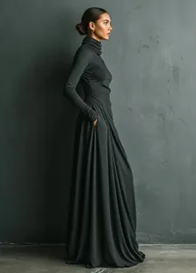 Side profile view of a woman wearing a dark grey stack neck maxi dress with pockets
