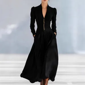 Detail view of an elegant black V-neck maxi dress with bubble sleeves and gold buttons
