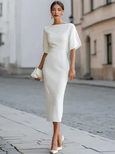 Detail view of an elegant white mid-sleeve dress for women in a street setting