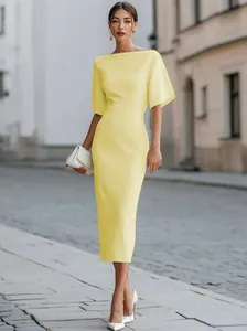Elegant pale yellow boat-neck midi dress with short sleeves shown in a street setting