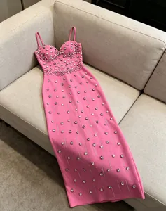 Elegant pink bandage slip maxi dress with intricate rhinestone beading detail.