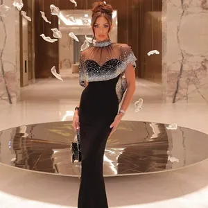 Detailed view of elegant black bandage evening dress with sparkling rhinestone cape overlay