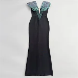 Detailed view of an elegant black bandage evening gown with teal beaded bust and deep V-neckline