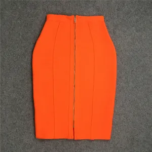 Detailed flat lay of a vibrant orange high-waisted bandage skirt with a gold front zipper