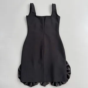 Back view of a black bandage mini dress with satin ruffle hem and zipper detail.