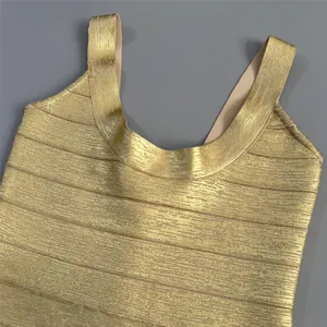 Close-up of gold metallic bandage dress showing textured ribbing and U-neckline