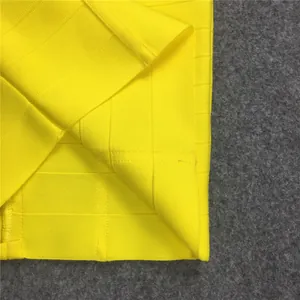 Detailed view of bright yellow elastic bandage skirt hem showing high-quality knit texture