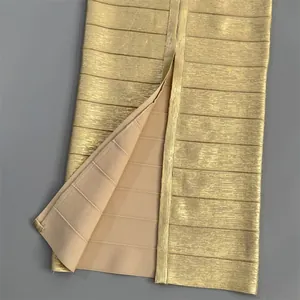 Close-up view of a gold shimmering bandage dress showing fabric texture and slit detail.