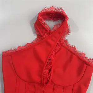 Detail of a red bandage dress featuring a halter neckline and delicate lace trim accents.