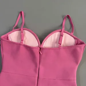 Close-up detail of the back zipper and adjustable straps on a pink bandage dress.