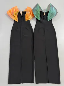 Back view of two elegant black bandage evening gowns with metallic ruffled shoulders.