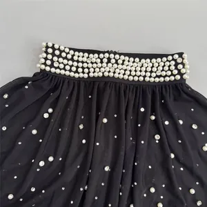 Close-up of black mesh evening shawl with elegant pearl and rhinestone embellishments