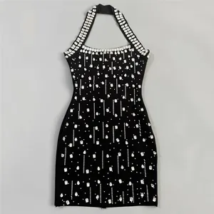 Flat lay of a black halter neck bandage dress with intricate rhinestone embellishments.