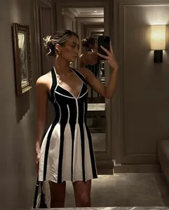 Mirror selfie που δείχνει την εφαρμογή ενός ασπρόμαυρου ριγέ halter bandage βραδινού φορέματος.