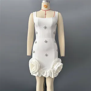 Close-up of white bandage dress with rhinestones and 3D rose ruffles at the hem.