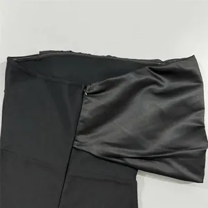 Close-up of the hidden zipper and smooth fabric texture on a black bandage dress