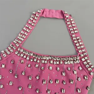 Close-up of pink halter evening bandage dress showing intricate rhinestone detailing