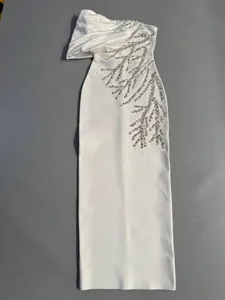 Detail of elegant white bandage maxi dress with sparkling silver rhinestone embroidery
