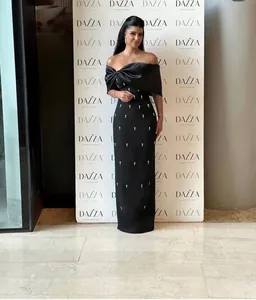 Elegant black off-the-shoulder long party dress with delicate crystal embellishments.