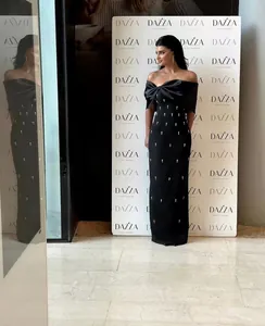 Elegant black off-shoulder long evening dress with bow detail and rhinestone accents