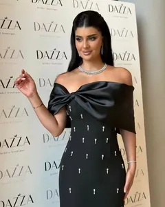 Elegant black off-shoulder bandage dress featuring a large bow and crystal details