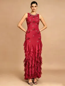 Detail of a red evening gown with 3D floral appliqués and elegant tiered ruffled mermaid skirt.