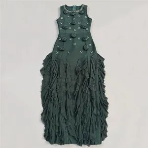 Detailed view of an elegant dark green ruffled evening gown with 3D floral accents and crystals