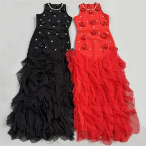 Detail of black and red evening gowns with 3D floral appliqués and ruffled tulle skirts.