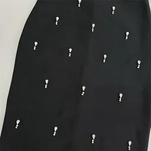 Detailed close-up showing crystal rhinestone embellishments on black bandage party dress fabric