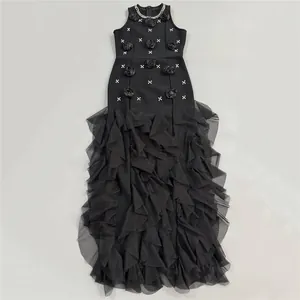Detail view of black evening gown with 3D rose appliqués and tiered ruffle skirt