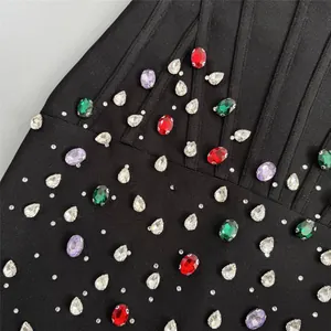 Exquisito detalle en primer plano de pedrería colorida en un sexy vestido bandage negro