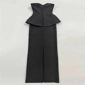 Elegante vestido largo palabra de honor negro con detalle de péplum en la cintura y abertura.