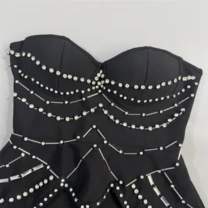 Detalle de un vestido bandage negro sin tirantes con pedrería y cuentas brillantes.