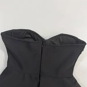 Vista trasera de un vestido bandage negro ajustado que muestra la cremallera y la pedrería