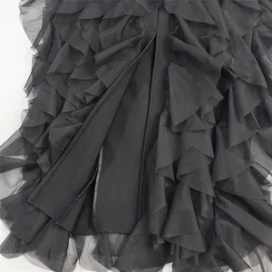 Close-up macro view of the tiered black tulle ruffle layers on a luxury bandage gown