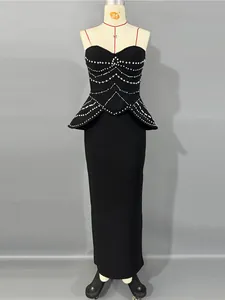 Vestido de noche bandage negro sin tirantes con detalles de peplum y strass.