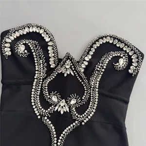 Detailed view of intricate rhinestone embroidery on a black bandage evening party gown