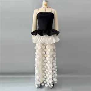 Detail of a chic color-block tube top evening gown with 3D polka dot sheer skirt.