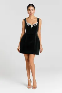 Detailed shot of dark green velvet mini dress with sparkling crystal neckline embellishments
