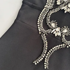 Close-up detail of luxury rhinestone embellishments on black bandage party dress