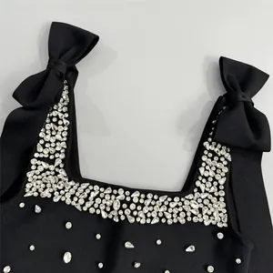 Vue détaillée d'une robe bandage noire avec strass scintillants et bretelles à nœuds