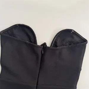 Close-up of black bandage dress neckline with rhinestones and back zipper detail