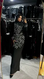 Detail shot of a black slim-fit maxi dress featuring intricate silver beaded branch patterns.